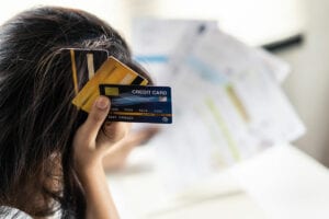 woman stressed holding credit cards