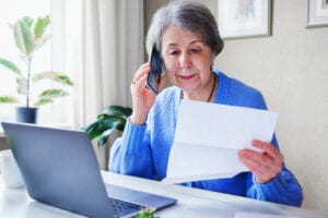 An elderly woman alls on the phone and finds out information about a loan or her savings