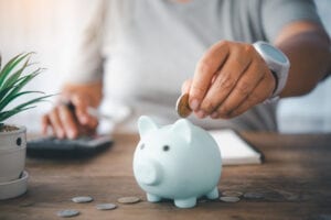 man putting coins in piggy bank